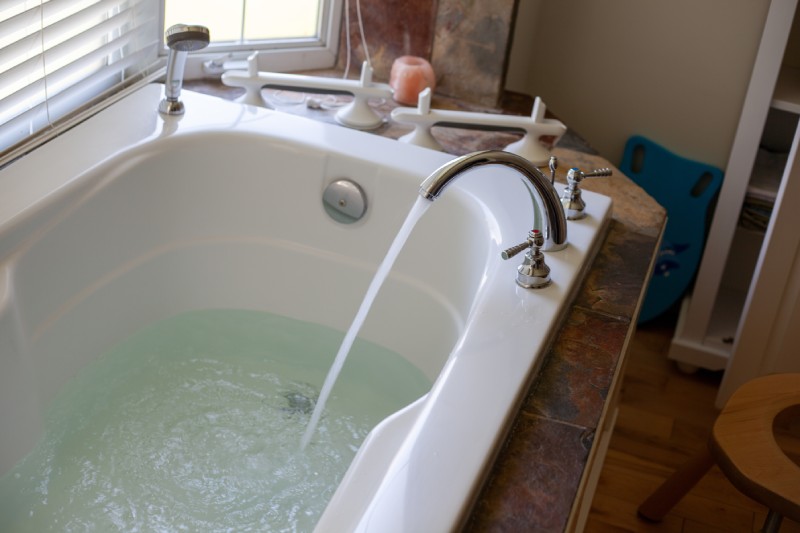 Filling deep white bath tub