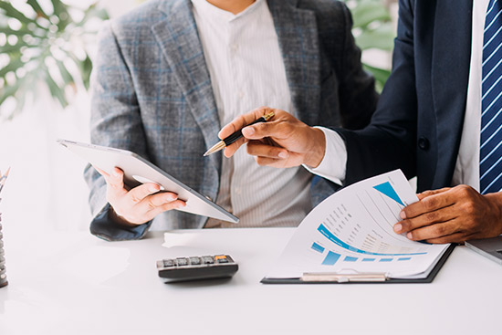 Two business professionals collaborate on a document related to insurance for Midland commercial property owners.