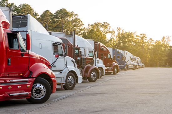A row of semi trucks parked in a lot, illustrating the fleet for Laredo transportation companies.