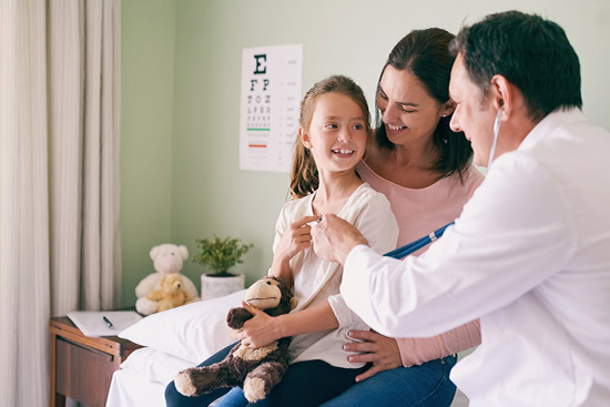 A doctor checks a child's health with a stethoscope, ensuring proper medical care in a healthcare environment.