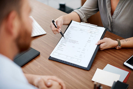 A man and woman review a business document focused on affordable car insurance options in McAllen.