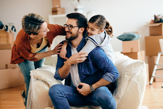 A family of three, a man, woman, and child, relax on a couch while exploring independent insurance options for 2026.