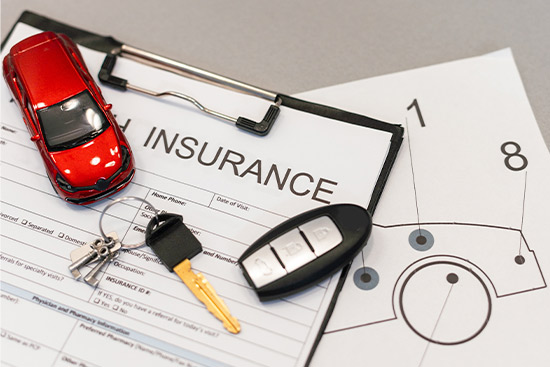 Coche rojo de juguete con llaves de coche en formulario de reclamación de seguro de automóvil y diagrama de informe de daños del vehículo que representa el seguro de automóvil y las reclamaciones por accidente.